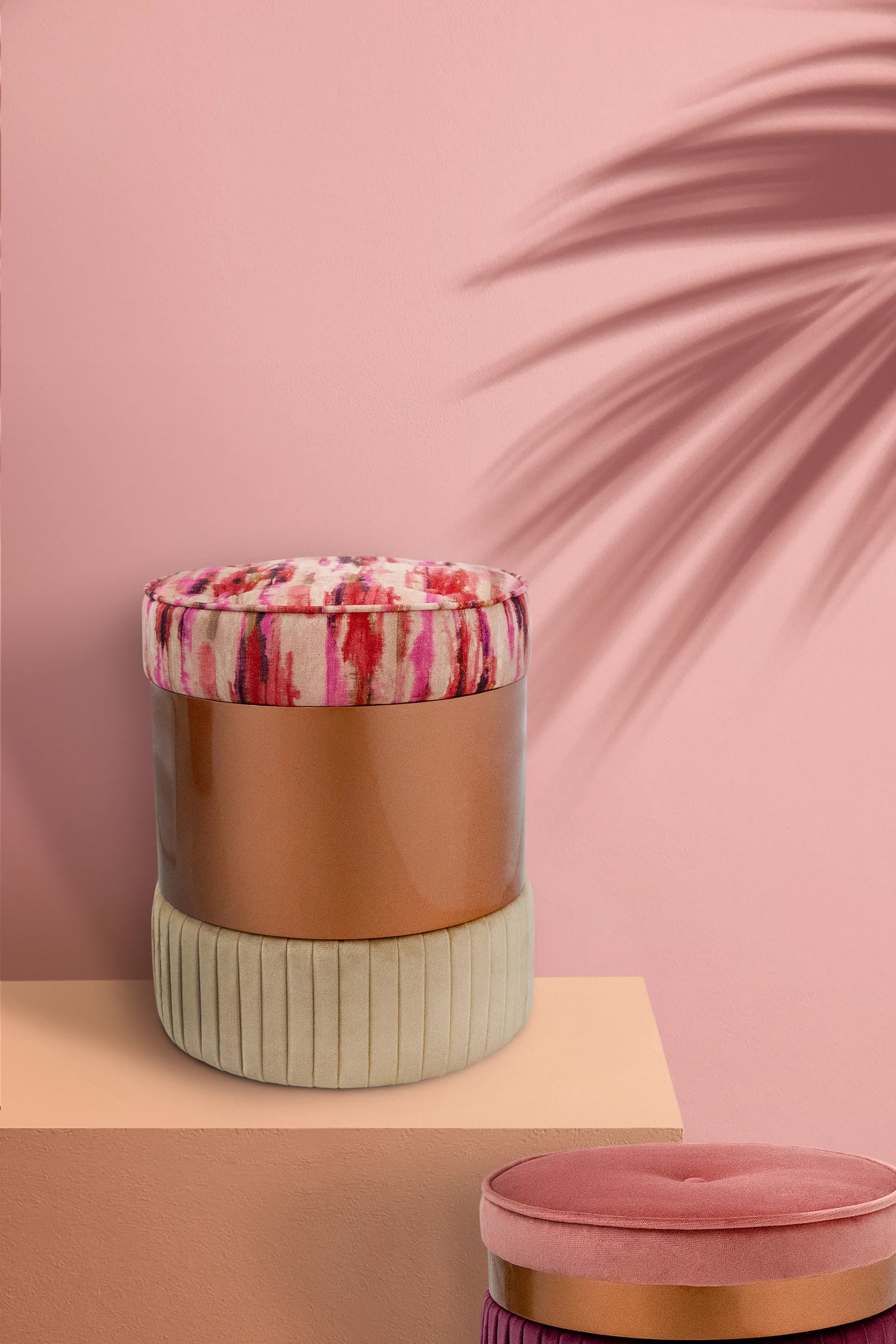 Chic Seville Pouf by KKbyKOKET, upholstered in colorful patterned and cream soft, plush fabrics, placed in a contemporary warm setting with a palm tree shadow.
