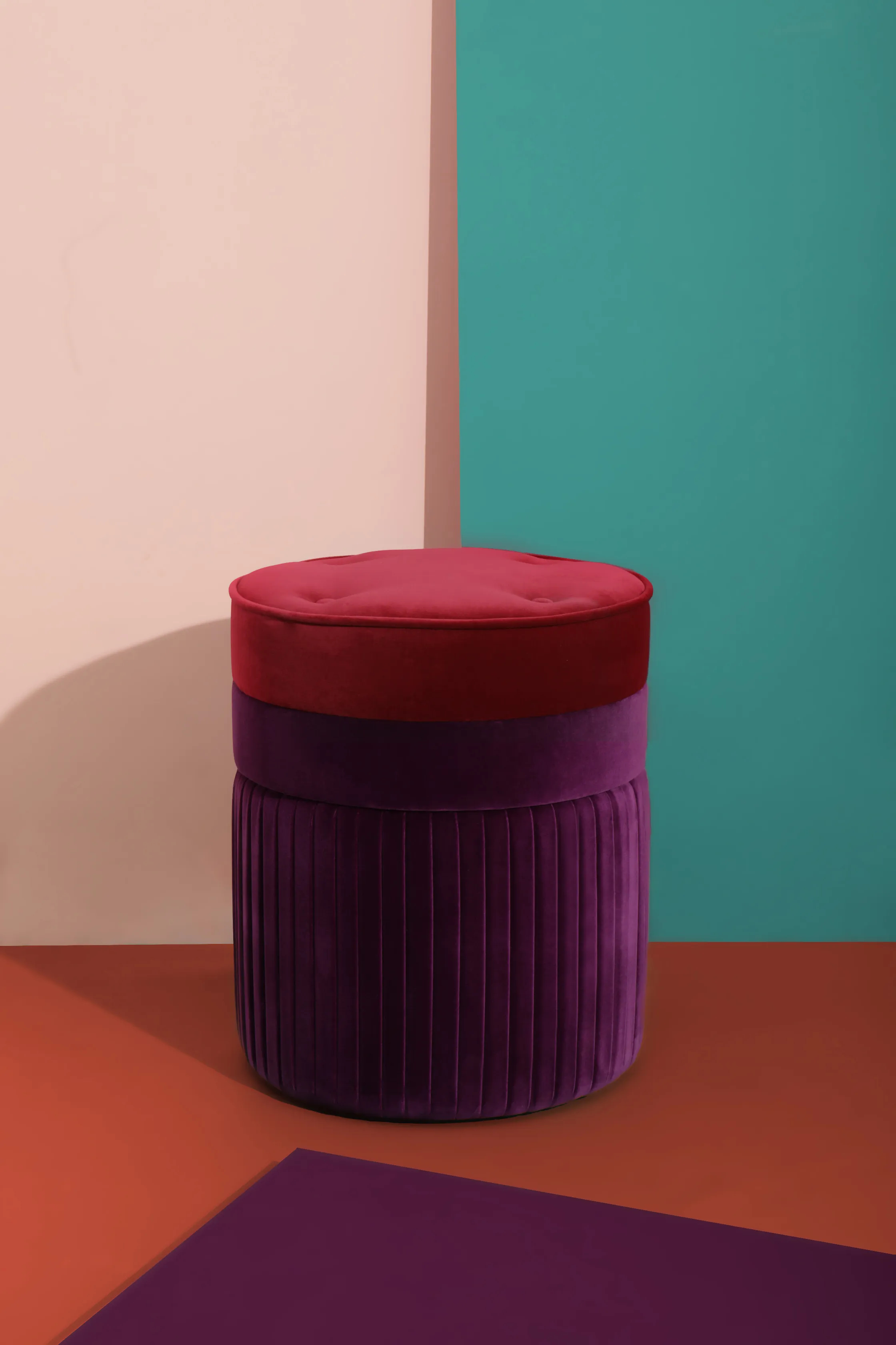 Elegant Valencia Pouf by KKbyKOKET, upholstered in dark pink and purple velvet fabric, highlighting with a sleek, modern design in a stylish and colorful setting.
