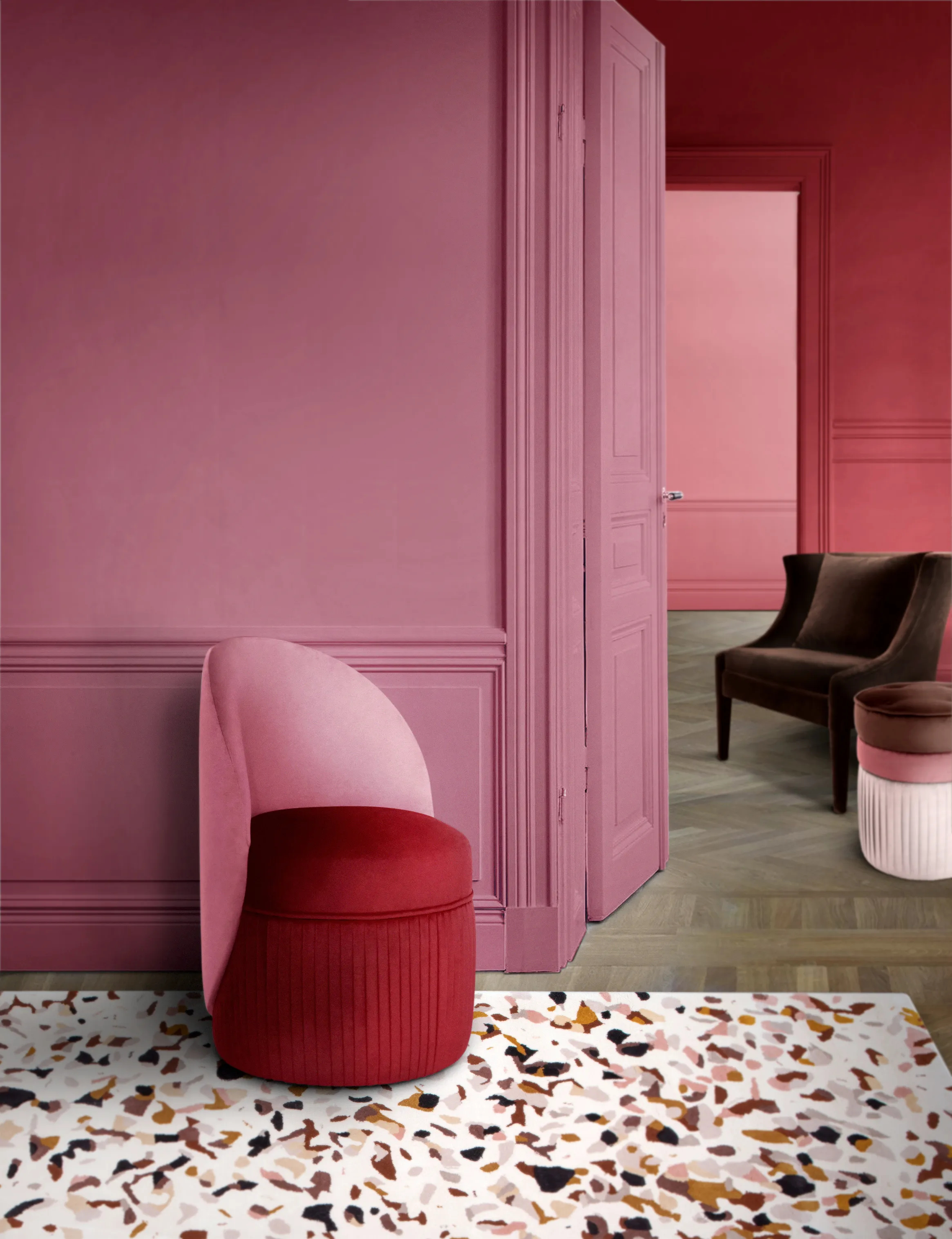 Pink-toned upholstery Venice Chair, dark velvet Athina Chair and light, medium and dark fabric Valencia Pouf by KKbyKOKET. The furniture is settled in an inviting environment with pink tones and a fun patterned rug.